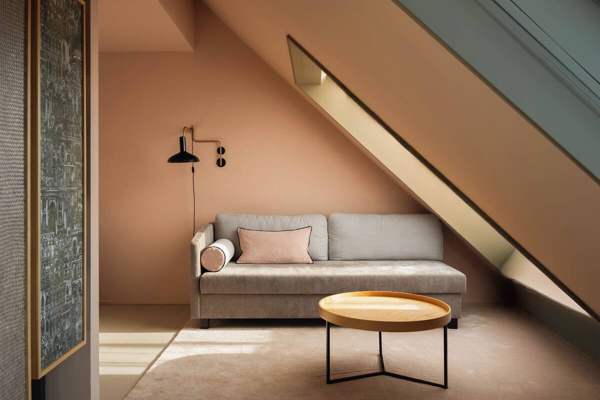 A modern living room with a sofa, a round wooden coffee table, and a black floor lamp.