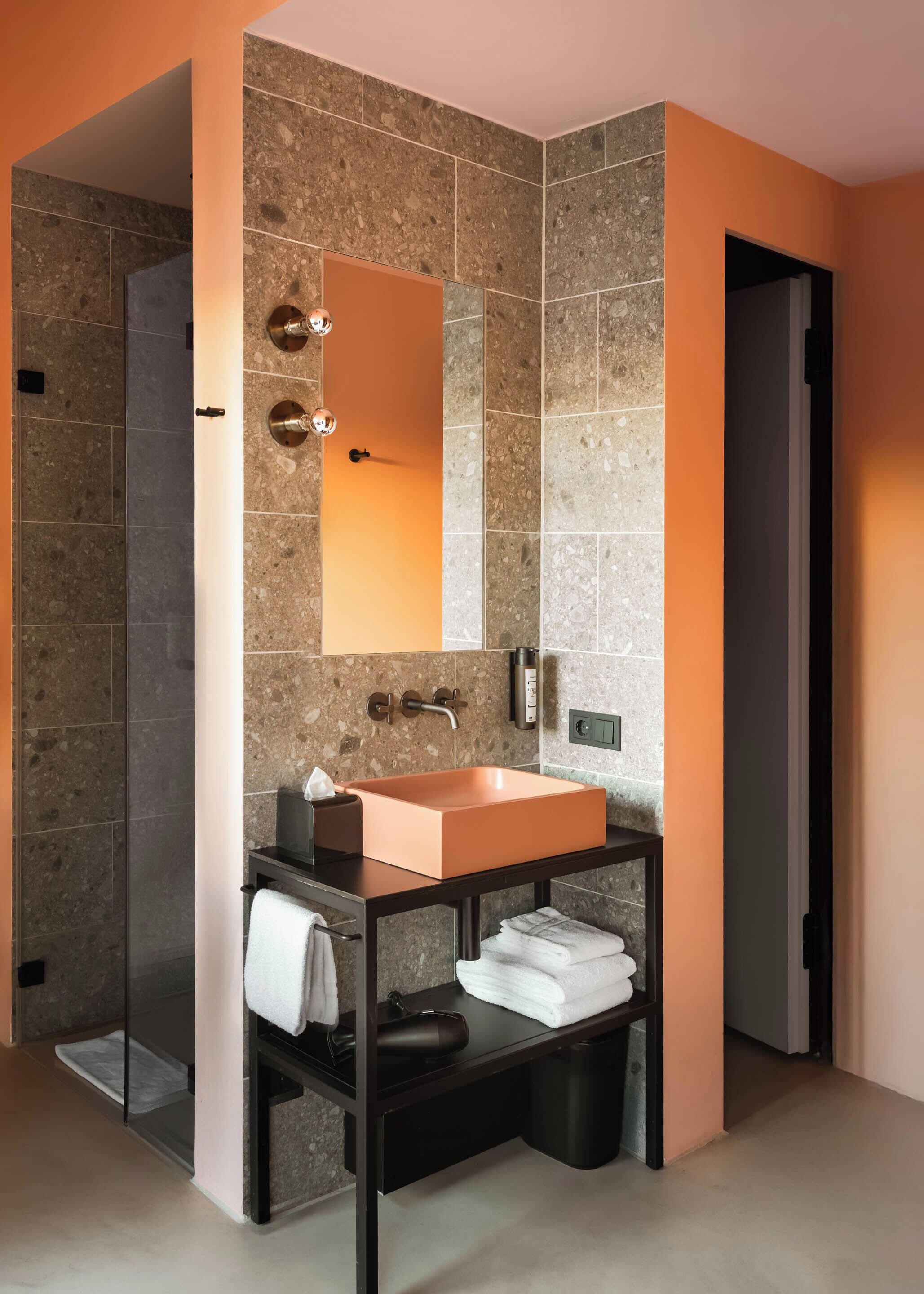 A modern bathroom with a rectangular sink, a large mirror, and a towel rack.