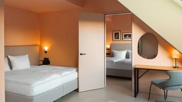 A hotel room with a bed, bedside table, lamp, chair, and a mirror on the wall.