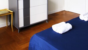 Una habitación de hotel con una cama, un tocador, un espejo y una puerta.
