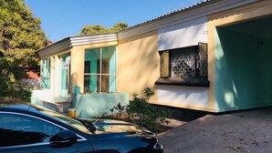 Una casa de dues plantes amb garatge, un cotxe estacionat al davant i una petita zona de jardí.