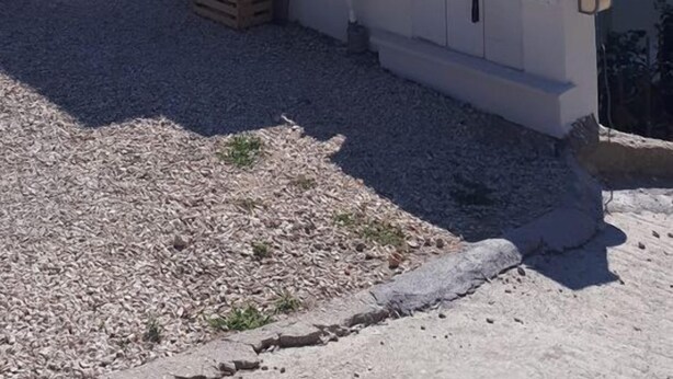 A two-story building with a satellite dish, a staircase, and a small outdoor area with a sink and wooden crates. - Apartments Šišević (Dubrovacko Primorje)
