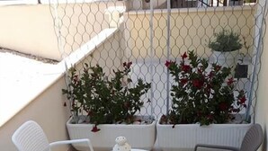 A patio with a round table, four chairs, and potted plants. - Apartments Šišević (Dubrovacko Primorje)