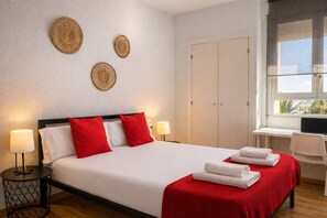 Habitación de hotel con una cama, dos lámparas de noche, un escritorio con una computadora portátil, una ventana con vistas y un armario.