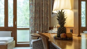 Een houten eettafel met een ananas, een appel en een citroen erop.