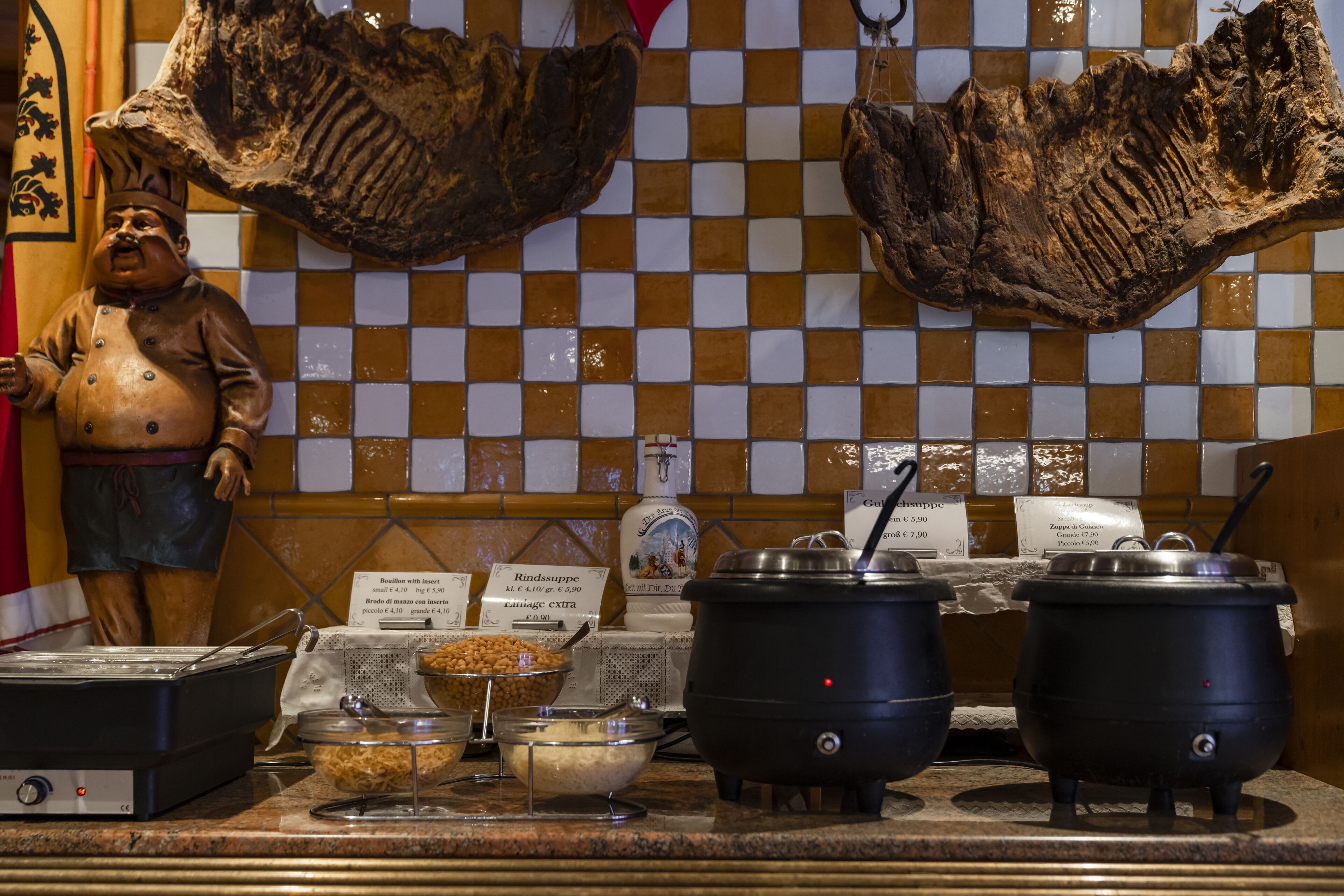 A buffet setup with various food items and cooking equipment.