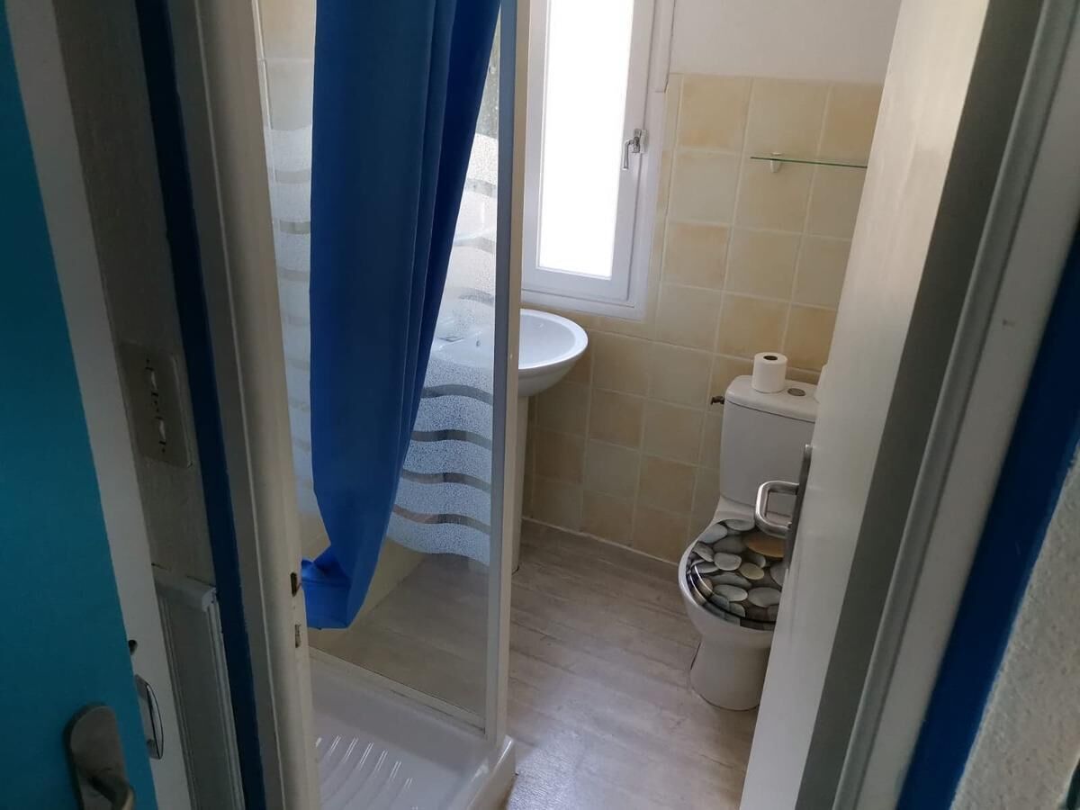 Une salle de bain comprenant des toilettes, un lavabo et un espace douche.