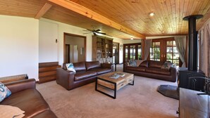 A spacious living room with leather sofas, a coffee table, and a fireplace.