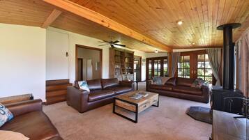 A spacious living room with leather sofas, a coffee table, and a fireplace.