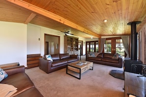 A spacious living room with leather sofas, a coffee table, and a fireplace.