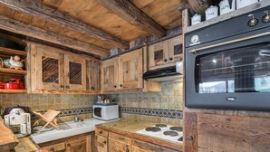 Une cuisine rustique avec des meubles en bois, un fourneau et un four à micro-ondes.