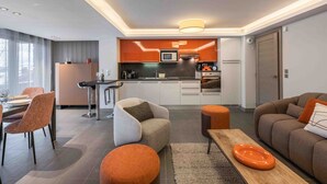 Een moderne woonkamer met een eethoek, een keuken en een zithoek.