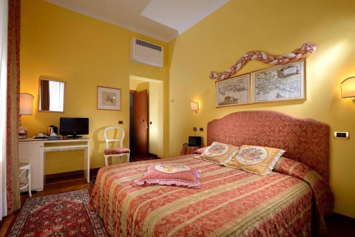 Een slaapkamer met een bed, een bureau, een stoel en een televisie.