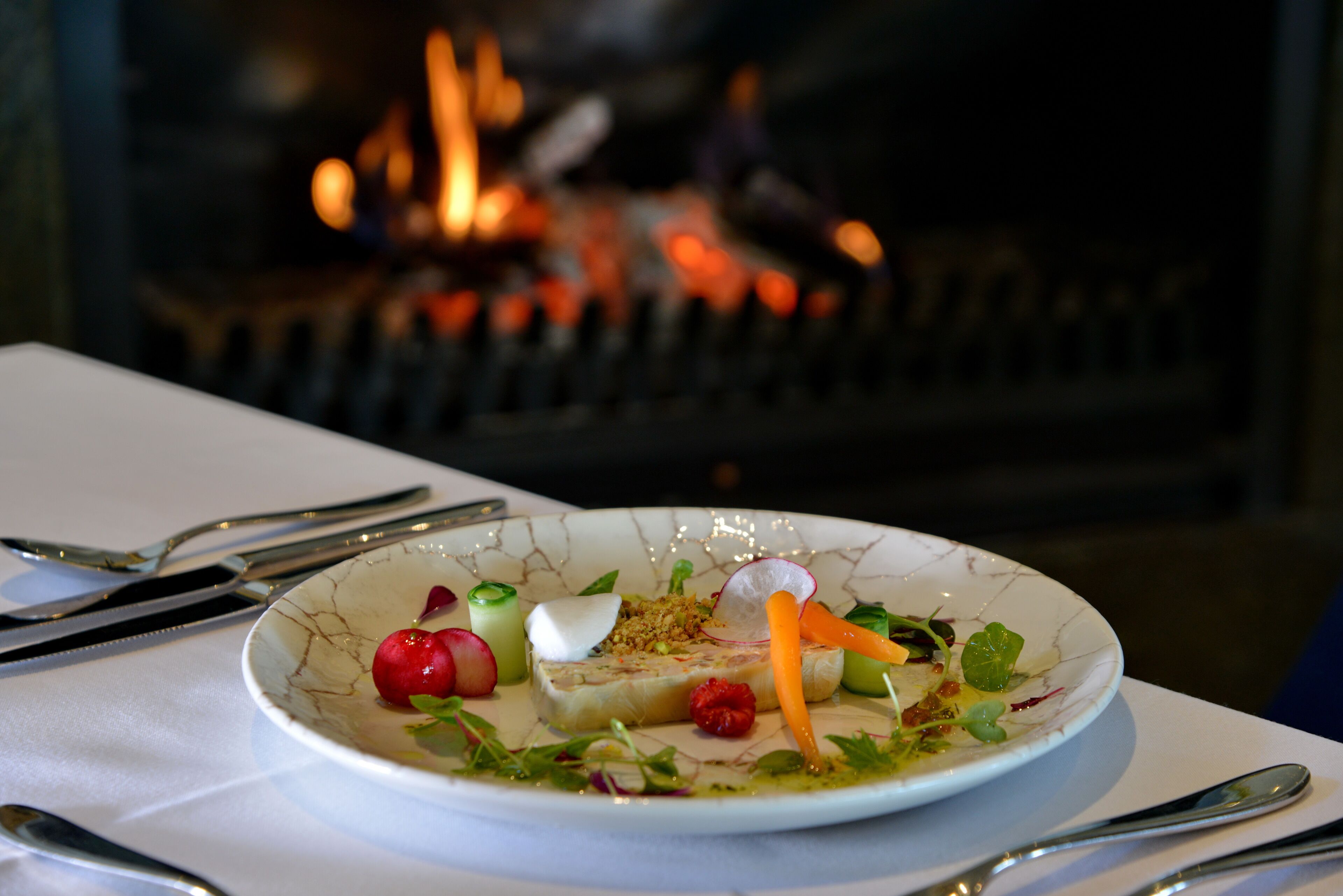 Un plato de comida con fuego al fondo.