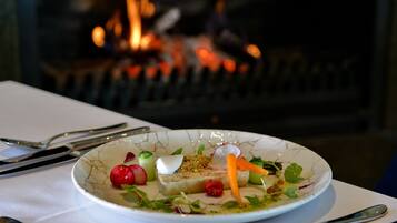 Un plato de comida con fuego al fondo.