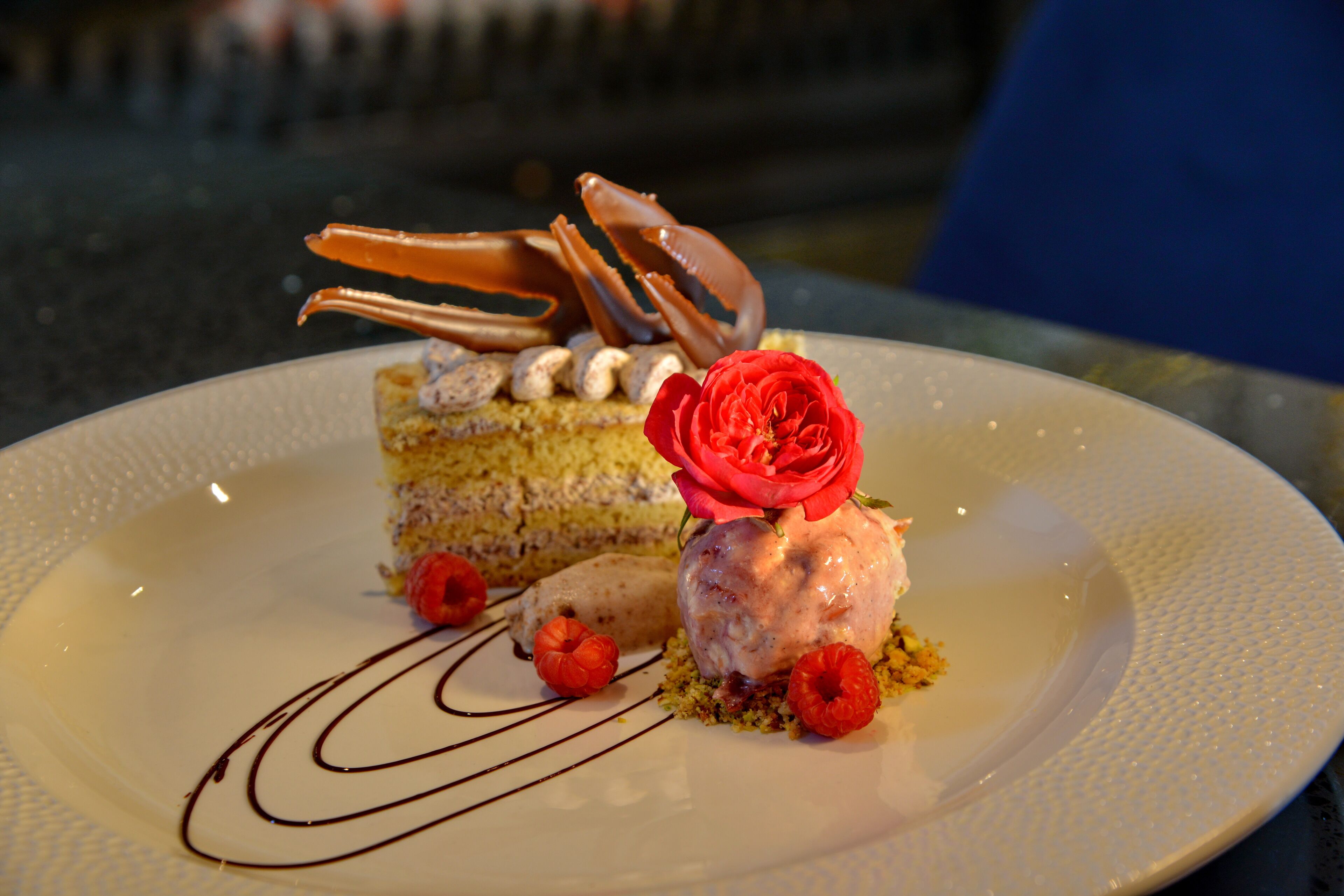 A dessert plate with a slice of cake, ice cream, and decorative elements.
