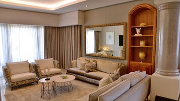 A spacious living room with a large sofa set, a coffee table, and a decorative mirror.