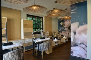 A salon with wooden paneling, large windows, and multiple seating areas.