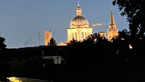 A large building with a prominent dome and a tall spire, surrounded by trees. - Tranquility and comfort in a modern and original setting! (Mantova)