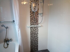 Bathtub, hair dryer, towels, toilet paper