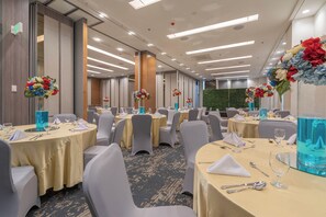 A banquet hall with round tables, grey chairs, and floral centerpieces. - Bayfront Hotel Cebu - Capitol Site (Cebu City)