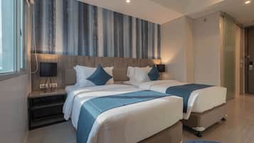 Een moderne hotelkamer met een groot bed, een zithoekje en een groot raam.