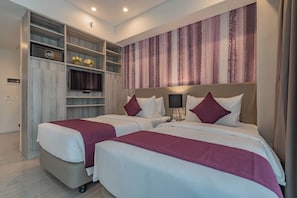 A hotel room with two beds, a minibar, a TV, and a large window with curtains. - Bayfront Hotel Cebu - Capitol Site (Cebu City)
