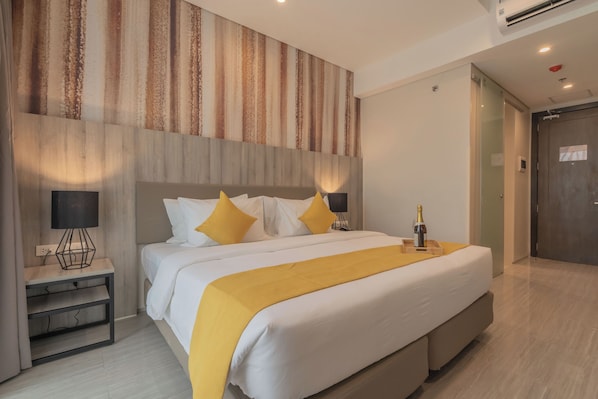 A modern hotel room with a large bed, bedside lamps, a nightstand, and a door. - Bayfront Hotel Cebu - Capitol Site (Cebu City)