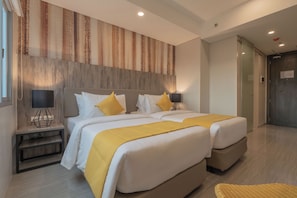 A hotel room with two beds, a large window, and a wooden headboard. - Bayfront Hotel Cebu - Capitol Site (Cebu City)