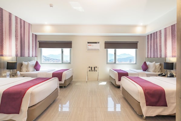 A hotel room with two beds, a view of mountains, and a ceiling-mounted air conditioning unit. - Bayfront Hotel Cebu - Capitol Site (Cebu City)