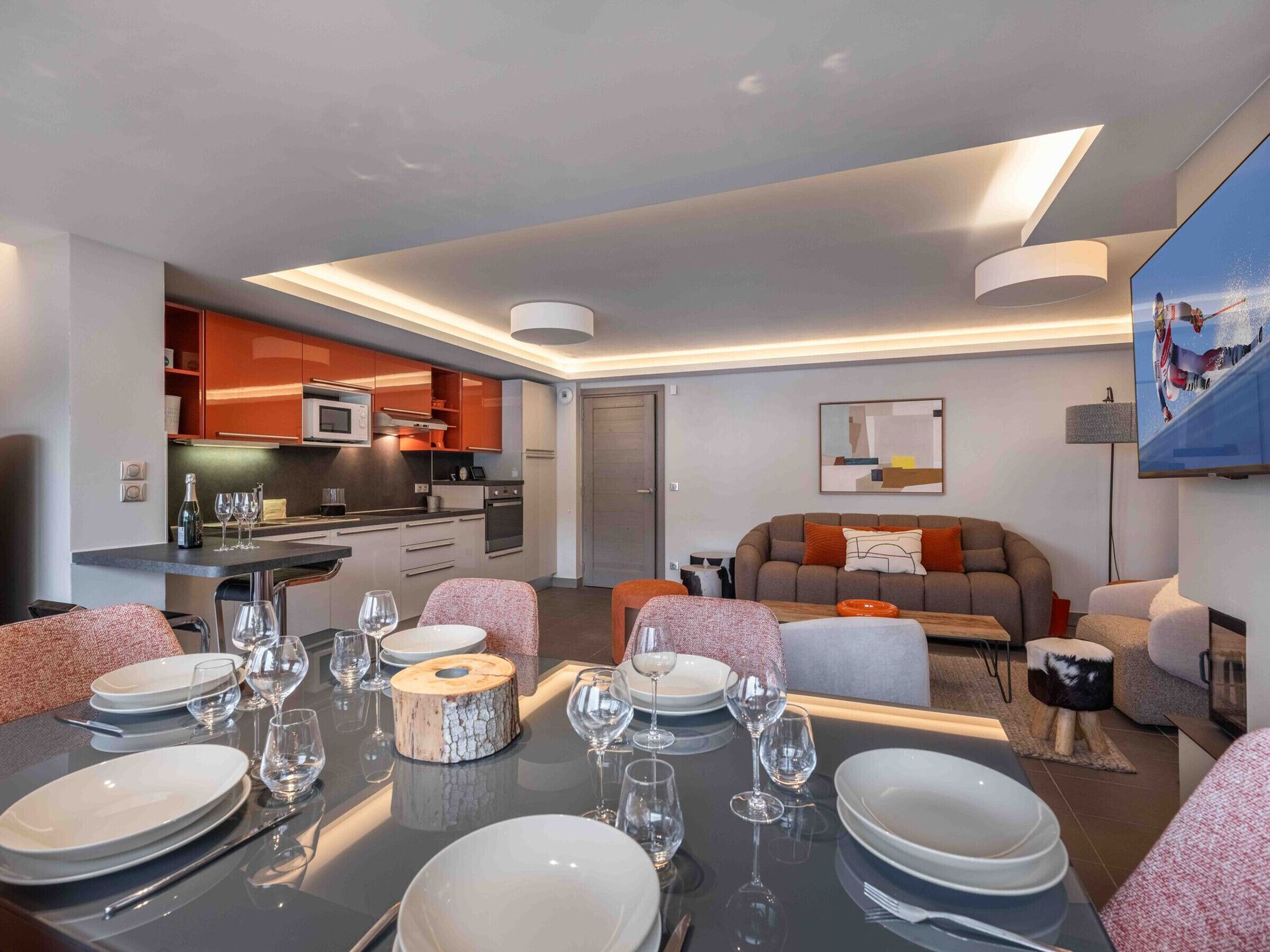 A modern living room with a dining area set for a meal.