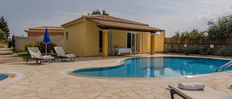 Alberca al aire libre y camastros