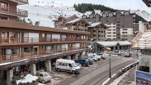 A hotel with multiple floors, balconies, and a ski slope in the background. - Cozy apartment in Courchevel with spacious bedroom and parking (Courchevel 1650)