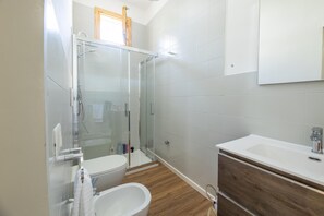 Een douche, een haardroger, een bidet, handdoeken