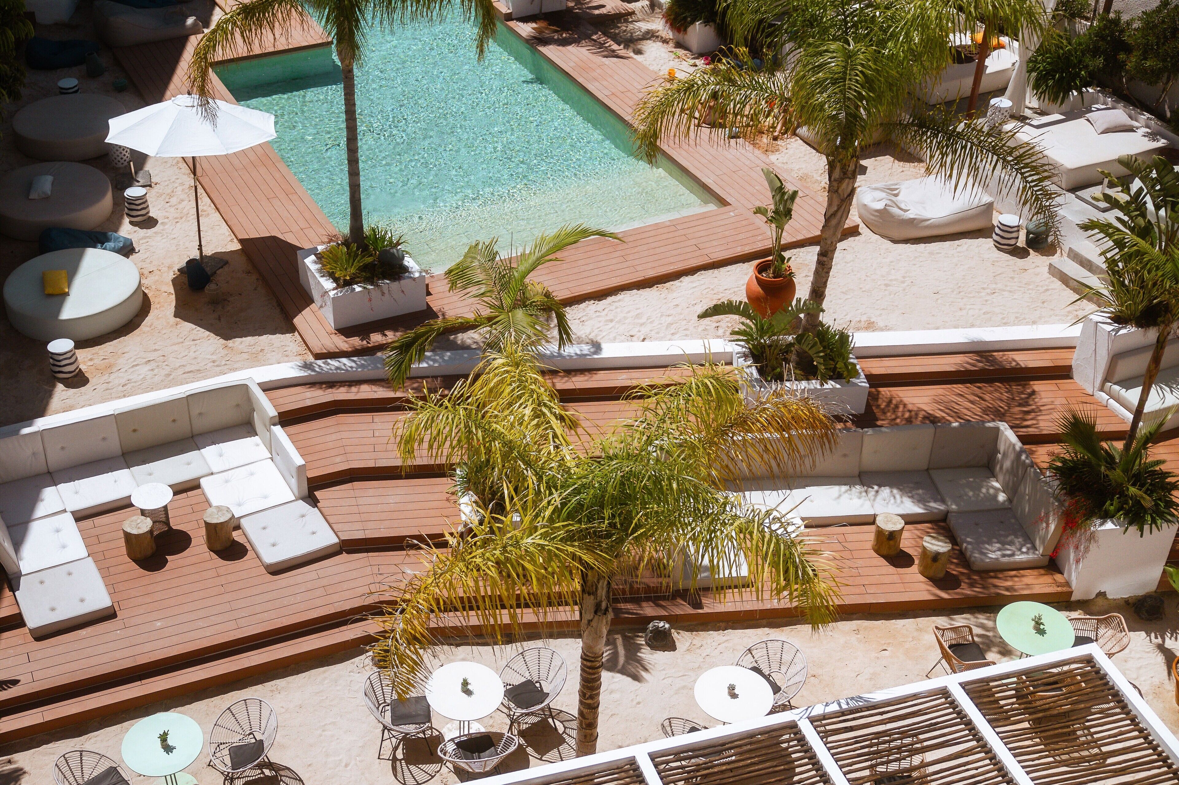 A rooftop pool area with sun loungers, a small pool, and outdoor seating.