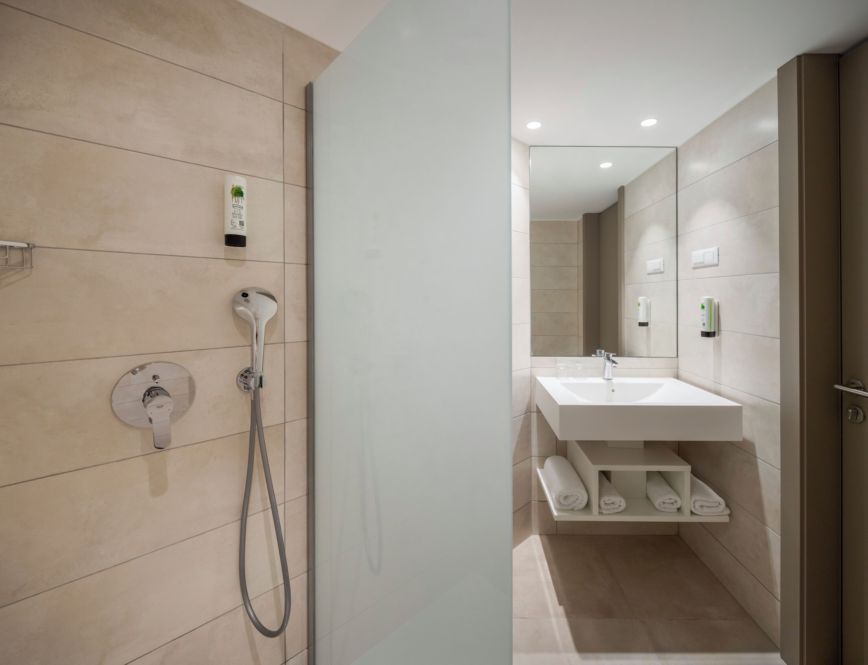 Une salle de bain moderne avec une douche, un lavabo et un miroir.