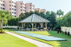 A gazebo with a metal roof and wooden beams, surrounded by a well-maintained lawn and trees. - 🌊Walk 2 Beach~2 Pools~Pool Views~2BR The Islander 211 (Destin)