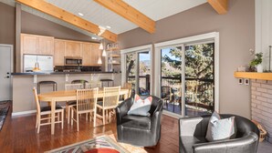 A spacious living area with a wooden dining table, black leather chairs, and a fireplace. - Access to Snowmass Mtn Via Trail! Balcony W/ Stunning Views, Pool/Hot Tub, Loft, Wood FP & Parking (Snowmass Village)