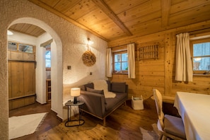 Ein gemütliches Blockhaus-Interieur mit einer Couch, einem Tisch und einem Kamin.