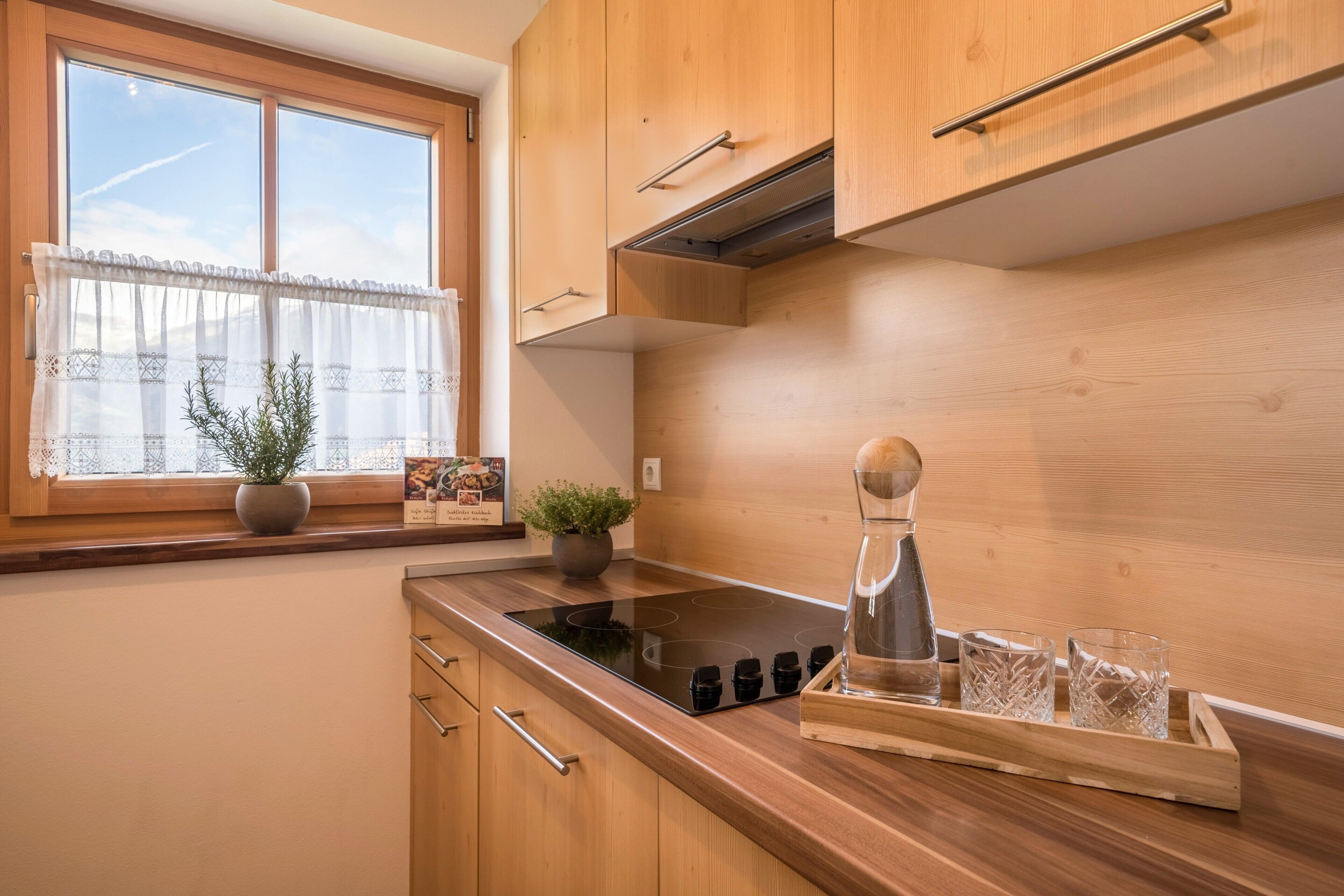 Una cocina con armarios de madera, una ventana con vistas, una estufa y una cafetera.