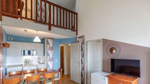 A compact apartment with a dining area, kitchenette, and a living space with a TV. - Pleasant duplex, parking - 7 guests (La Mongie)