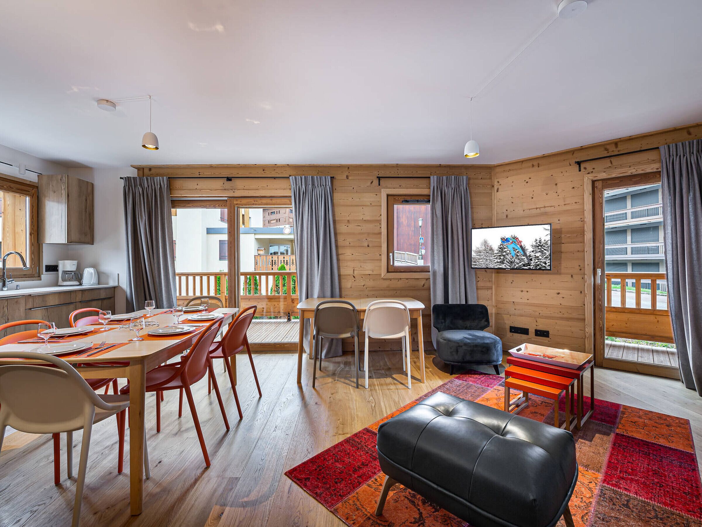 A cozy room with a dining area, a sofa, and a TV.