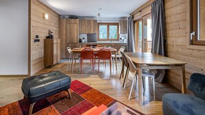 A modern interior with a wooden dining area, a kitchen, and a living space. - Modern apartment in Courchevel, near slopes (Courchevel 1650)