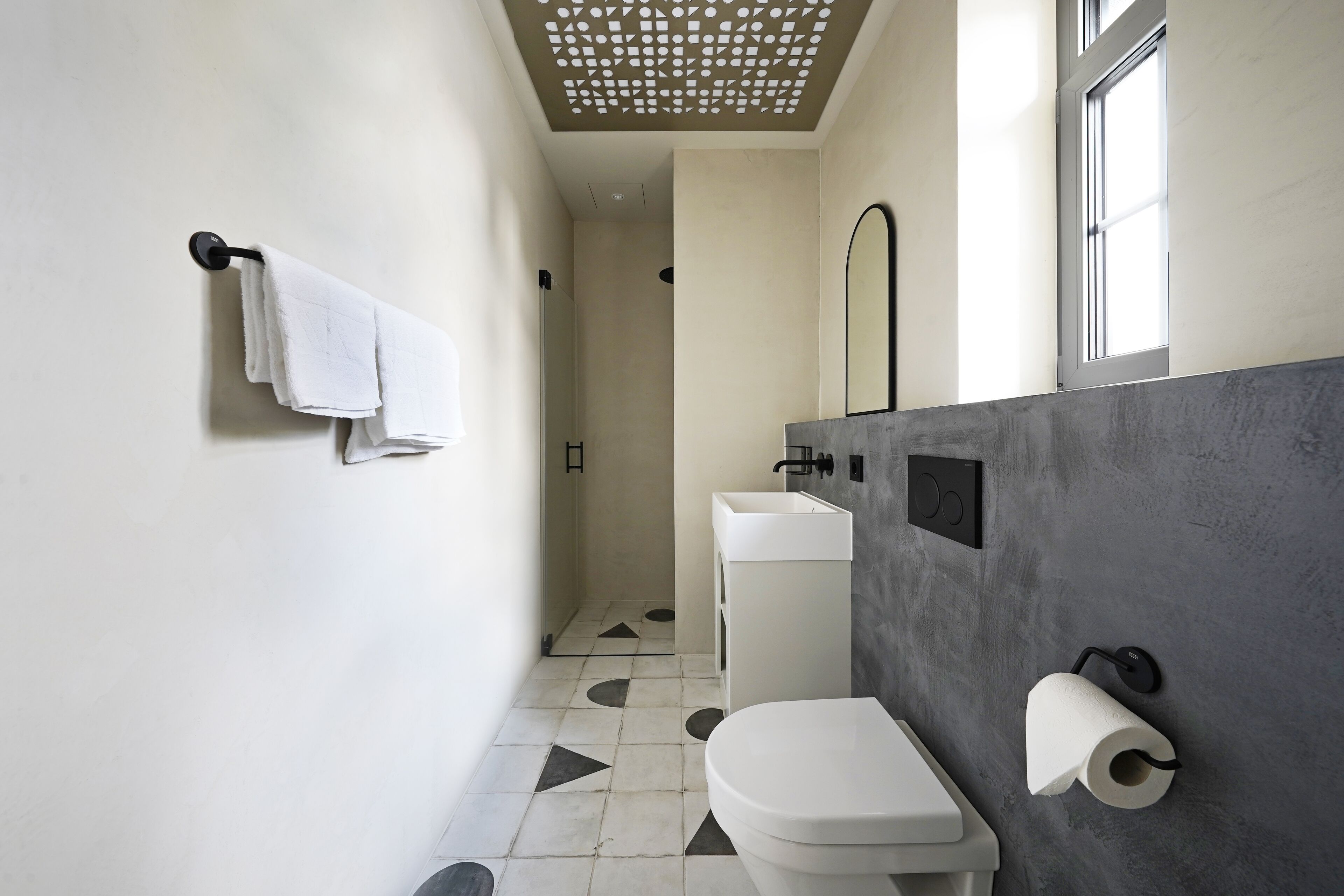 A modern bathroom with a toilet, sink, and shower.