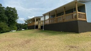 A two-story building with a covered porch and a fenced yard.