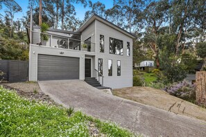 A modern two-story house with a garage, a balcony, and a driveway leading to the entrance. - Wye Times (Wye River)