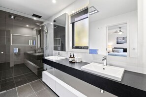 A modern bathroom with two sinks, a shower, and a large mirror. - Wye Times (Wye River)