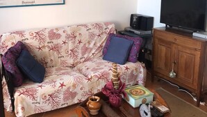 A living room with a sofa, a coffee table, and a TV.
