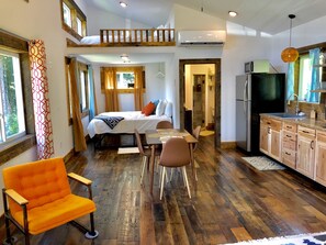 Quarto espaçoso com beliche, área de refeições e cozinha.