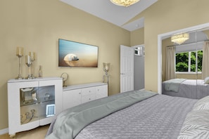 Un dormitorio con cama, cómoda, televisor y una puerta que da a otra habitación.